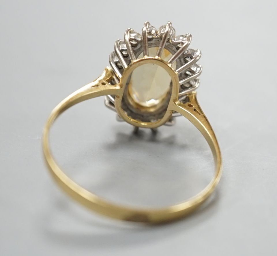 A modern yellow metal, yellow topaz and diamond set oval cluster ring, size T, gross weight 3.7 grams.